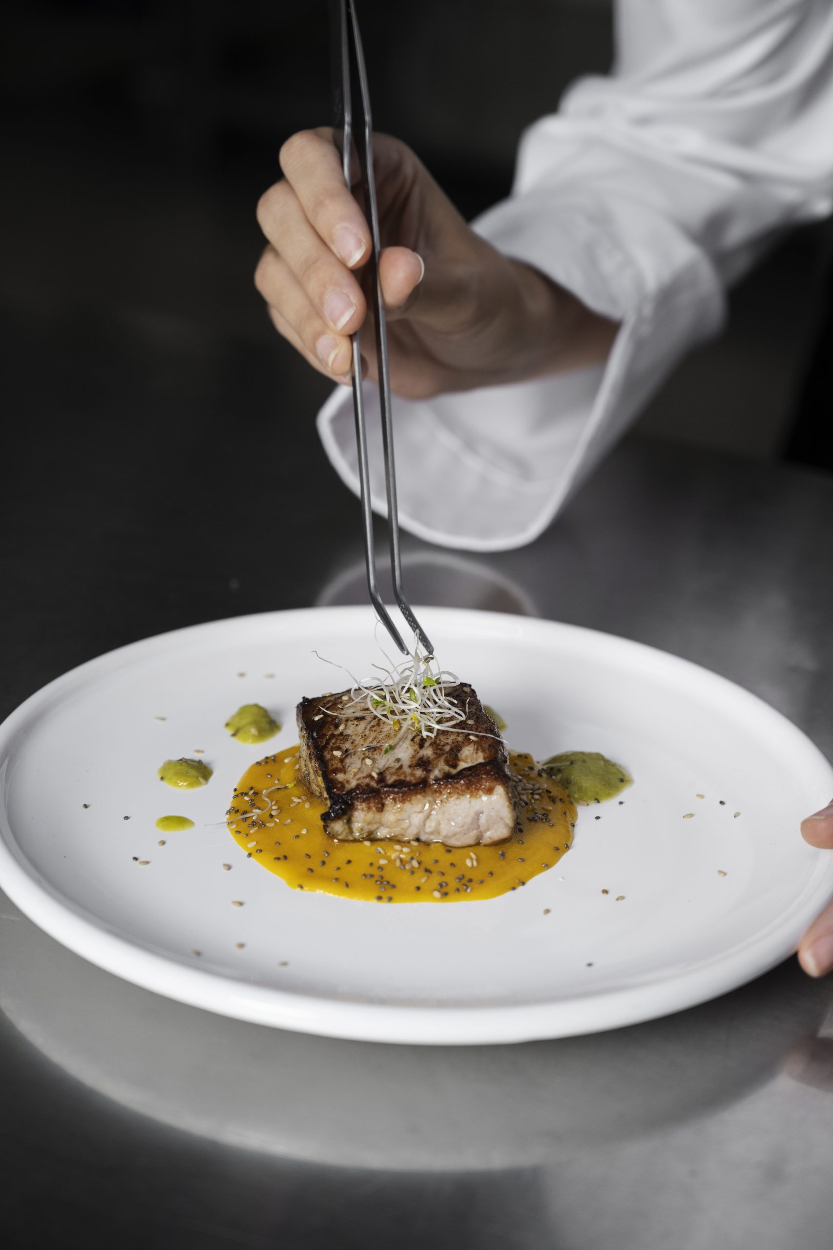 cocinera emplatando pescado 